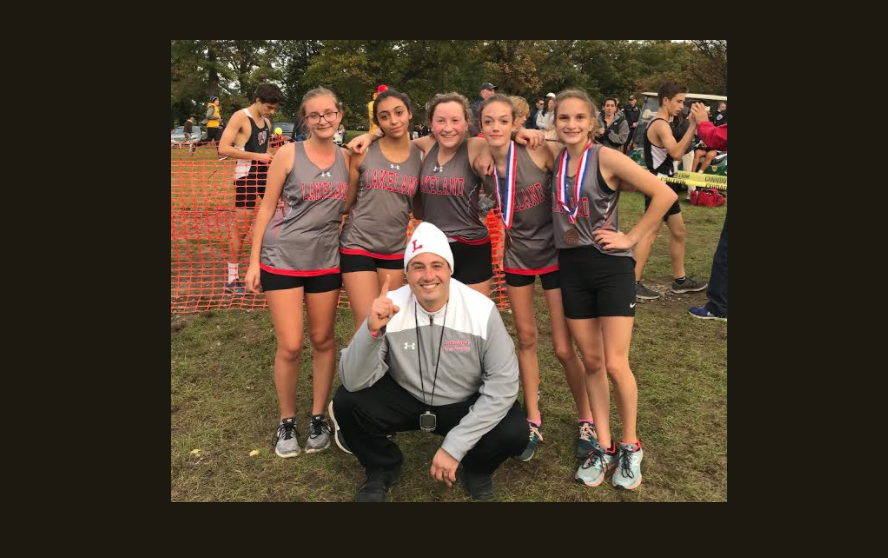 The 2018 girls varsity XC team with Coach Conforti
