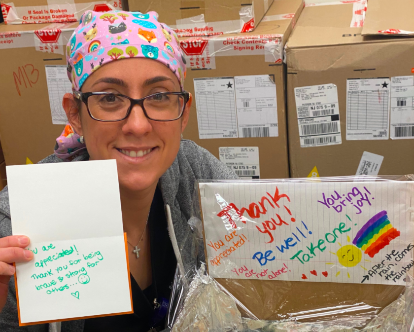 Health worker smiling with thank you cards and cupcakes.