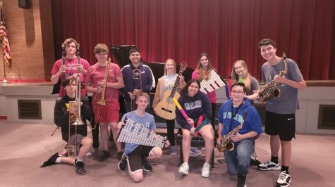Tri-M Music Honor Society poses in the auditorium with collected instruments. The drive was held throughout the month of April.