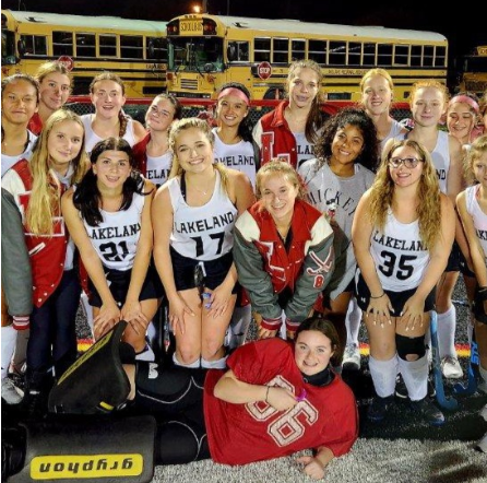 Varsity field hockey smiling after a victory.
