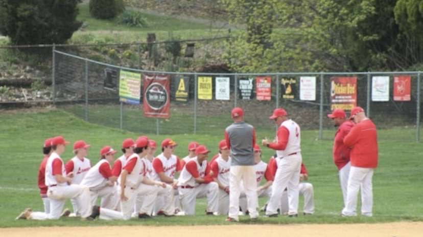 The LRHS baseball team having a discussion with their coach after the end of a scrimmage.