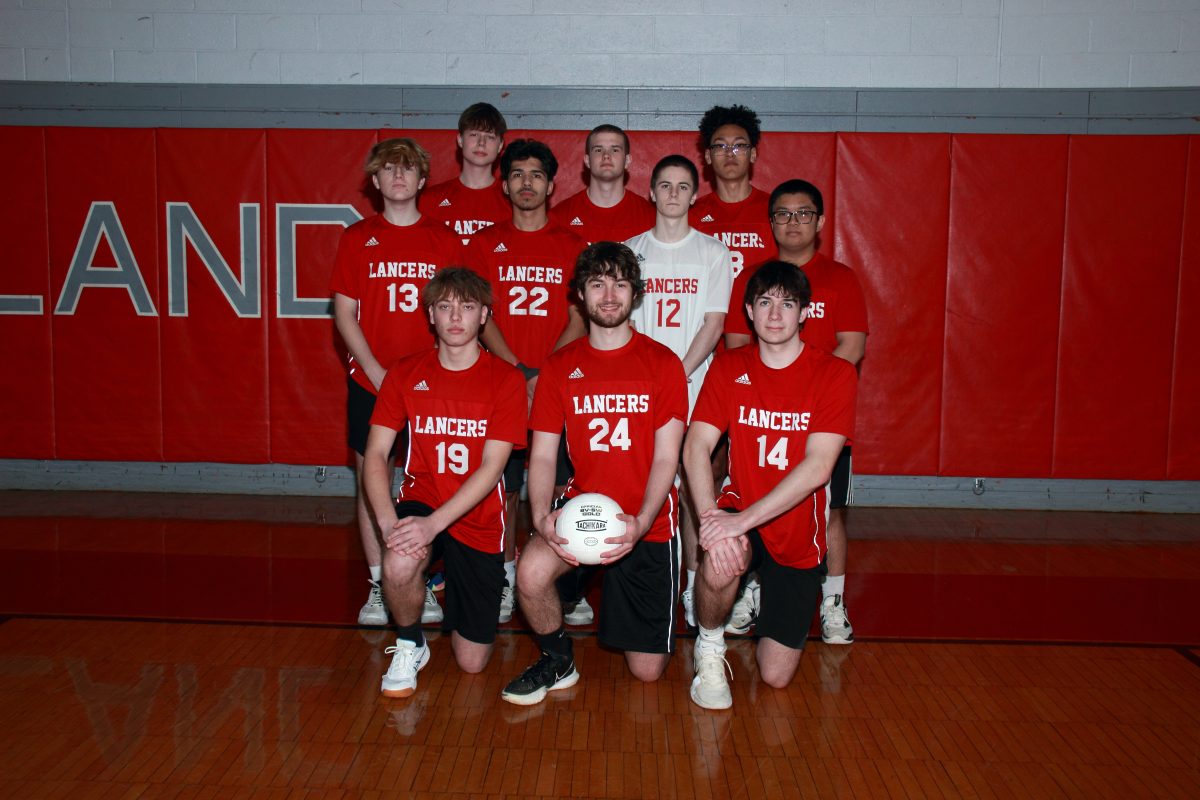 The varsity boys volleyball team pose for a photo.