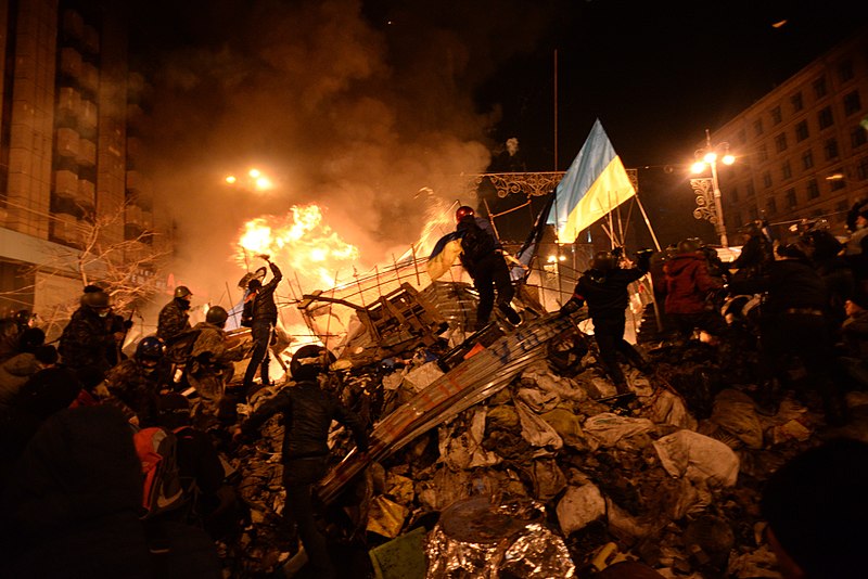 State+flag+of+Ukraine+carried+by+a+protester+to+the+heart+of+developing+clashes+in+Kyiv%2C+Ukraine.+Events+of+February+18%2C+2014.